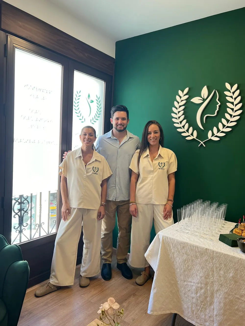 Parte del equipo de Olimpia ante la pared verde con el logo de la clínica