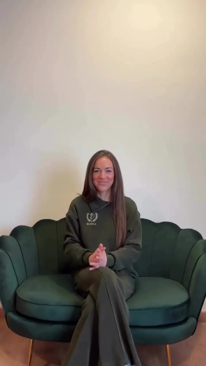 Profesional de Olimpia sentada en el sillón de terciopelo verde de la sala